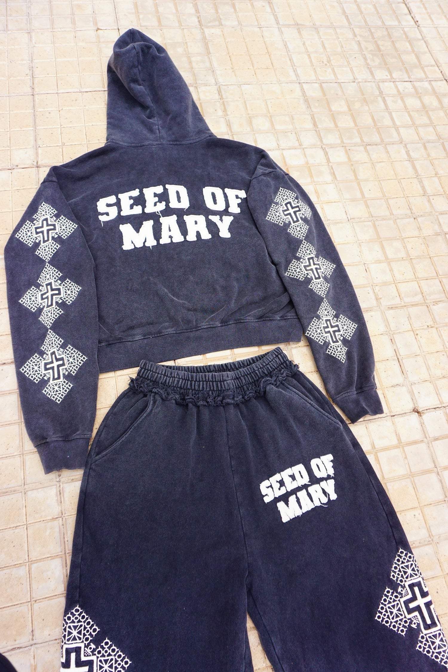 Navy blue outfit with white text and patterns on a textured surface
